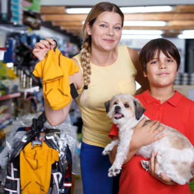 γυναίκα με γιο και σκύλο διαλέγουν ρούχα σκύλου
